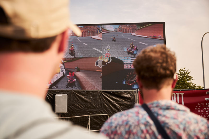 Gäste spielen Mario Kart auf der LED-Wand